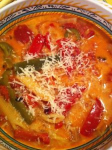 Colorful penne pasta soup with tomatoes and peppers